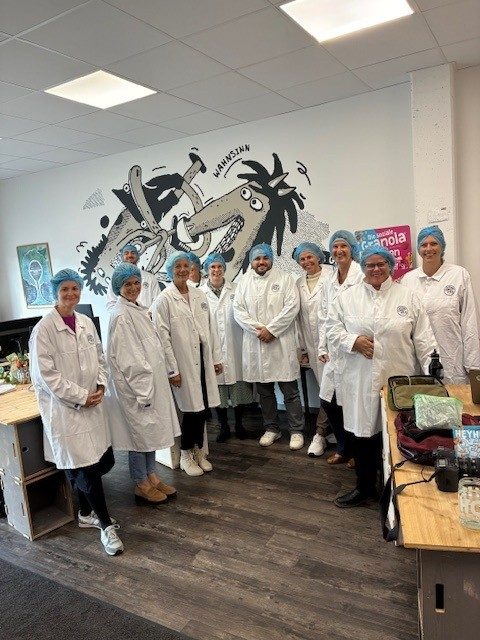 Foto der Teilnehmenden in Schutzkleidung der Betriebsbesichtigung des Arbeitskreis Arbeit bei der sozialen Müslirösterei HEYHO