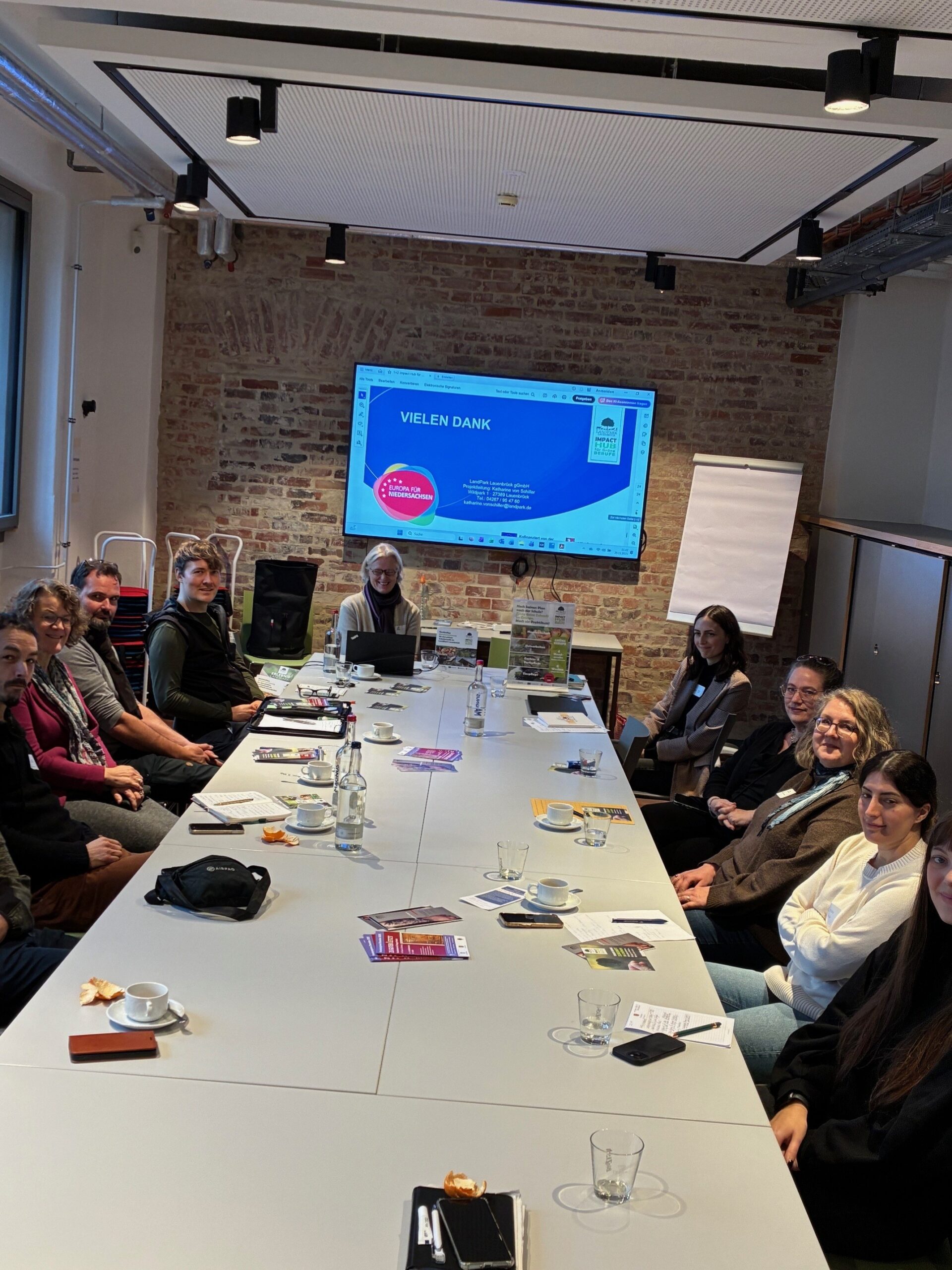 Teilnehmende der Veranstaltung Netzwerktreffen Impact Hub für grüne Berufe sitzen am Konferenztisch